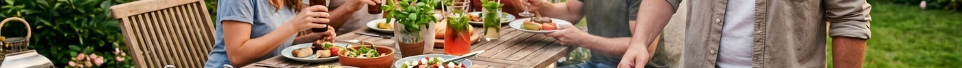 Stimmungsvolle Gartenparty am Abend. Freunde sitzen an einem langen Holztisch mit Salaten und Getränken, beleuchtet von Lichterketten und Laternen. Ein Mann am Kugelgrill bereitet das Essen zu.