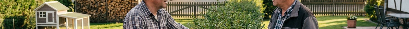 Zwei Nachbarn stehen am Gartenzaun und unterhalten sich.