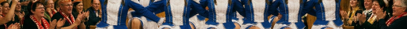 Eine Funkengarde tanzt beim Karneval. Das Publikum singt mit, klatscht und freut sich.