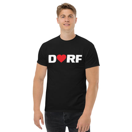 Ein Mann trägt das schwarze Dorfliebe Männer T-Shirt mit der Aufschrift DORF. Der Buchstabe O ist durch ein rotes Herz ersetzt.