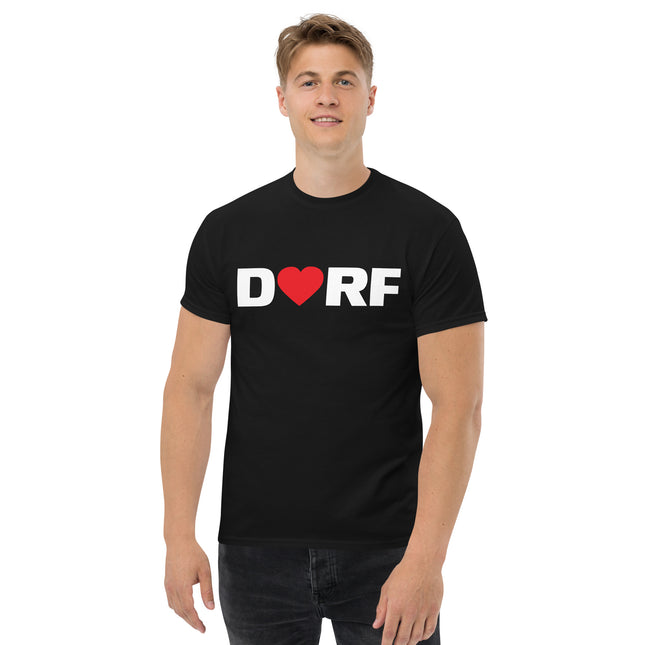 Ein Mann trägt das schwarze Dorfliebe Männer T-Shirt mit der Aufschrift DORF. Der Buchstabe O ist durch ein rotes Herz ersetzt.