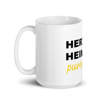 Eine weiße Tasse mit der Aufschrift Herz, Heimat & pures Leben.